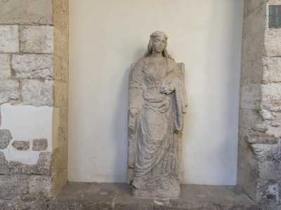 ...la Santa Caterina in pietra calcarea che una volta ornava il pozzo al centro del chiostro